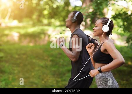 Concept de course matinale. Black sportif Homme et Femme jogging en plein air dans le parc Banque D'Images