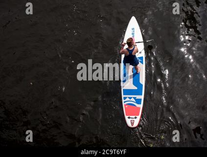 Hambourg, Allemagne. 02 août 2020. Une femme fait une promenade en paddleboard (SUP) le long d'un canal sur l'Alster. Credit: Daniel Bockwoldt/dpa/Alay Live News Banque D'Images