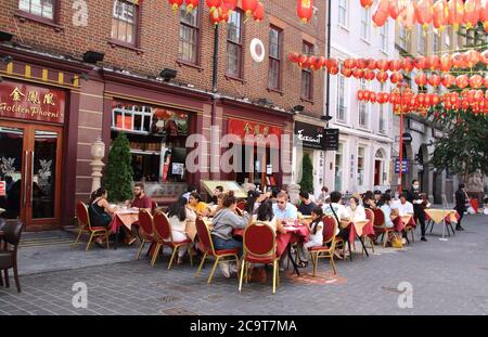 Londres, Royaume-Uni. 1er août 2020. Les gens mangent à l'extérieur dans un restaurant avec toutes les lanternes colorées de Chinatown.LOIN des rues vides et désolées des jours de « verrouillage », le quartier chinois de Londres a adopté la nouvelle culture de restauration en plein air et les rues sont plus animées et les restaurants font de nouveau bon affaires à Gerrard Street. Crédit : SOPA Images Limited/Alamy Live News Banque D'Images