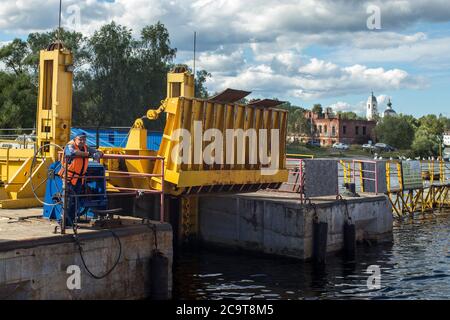 Myshkin, Russie - 26 juillet 2020, UN employé de ferry attend le ferry pour amarrer et amarrer. Le passager attend la fin du voyage. Banque D'Images