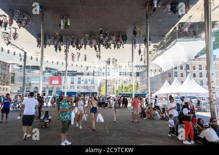 Les gens se reflètent dans la voûte en miroir de l'Ombrière de Norman Foster, Marseille Banque D'Images