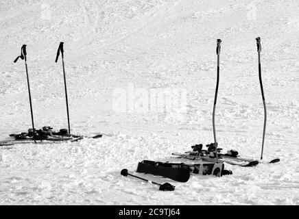 Équipement de ski : bâtons de ski, skis sur piste enneigée ensoleillée le jour de l'hiver. Image en noir et blanc. Banque D'Images