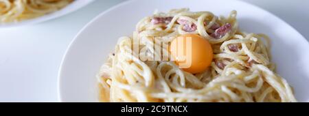 Pâtes Carbonara avec jaune d'œuf et bacon de fond fermé Banque D'Images