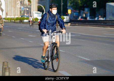 Madrid, Espagne - 22 mai 2020 : jeune homme en vélo et masque à cause du Covid-19 Banque D'Images