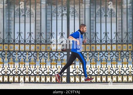 Madrid, Espagne - 22 mai 2020 : un jeune homme fait du sport à la porte du Palais Royal de Madrid. Banque D'Images