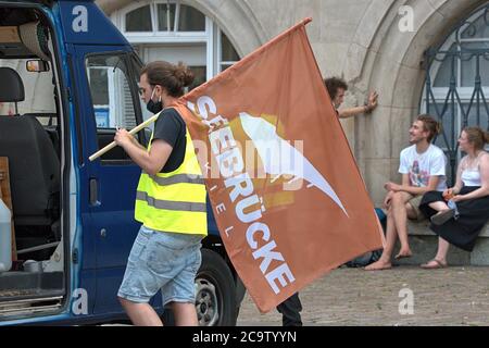 01.08.2020, Kiel, impression de la démo: 'Seebrucke au lieu de Seehofer - même combat, année différente!', à laquelle l'organisateur, Seebrucke Kiel, a appelé. Le but du rallye était la place de l'hôtel de ville. Le Seebrucke appelle à un programme d'admission de l'Etat SH pour les réfugiés des camps grecs, à la dépénalisation du sauvetage en mer et du vol! La fin de la répression contre le sauvetage en mer des civils, la libération des navires, la fin de la politique raciste de forclusion. Sur l'image le drapeau avec le logo de la Seebrucke Kiel. | utilisation dans le monde entier Banque D'Images