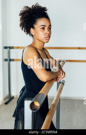 Portrait de la danseuse de ballet afro-américaine debout à la barre studio Banque D'Images