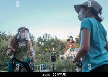 Jérusalem, Israël. 2 août 2020. Un jeune visiteur interagit avec une fée comme «Terre des contes de fées» s'ouvre aux jardins botaniques de l'Université hébraïque à Jérusalem. Le spectacle interactif offre une expérience de conte de fées orientée famille illuminée par un éclairage magique et avec Pinocchio, Grandpa Geppetto, Elsa, Rapunzel, Alice from Wonderland, Humpty Dumpty, Peter Pan, Tincubell et d'autres, conformément aux directives restrictives du coronavirus du ministère de la Santé. Crédit : NIR Amon/Alamy Live News Banque D'Images