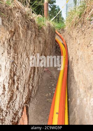 Câbles multiconducteurs dans la tranchée. Nouvelle connexion Internet haut débit filaire. De nombreux fils colorés dans une tranchée. Banque D'Images