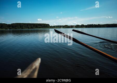 les athlètes en vacances sont engagés dans l'aviron, les nageurs sur des oars en bois frappent l'eau, éclaboussant beaucoup de gouttes autour Banque D'Images