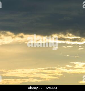 Ambiance nuageux sur le lac de Garde en Italie. Nuages sombres contre le ciel lumineux. Un oiseau vole seul à travers le ciel. Des morceaux de nuage se sont répandus. Banque D'Images