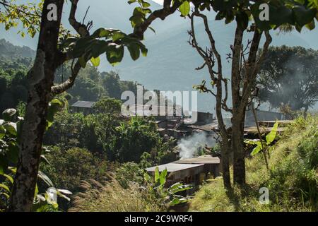 Fumée s'élevant d'un beau village de montagne sur la colline, Bahundanda, circuit Annapurna, Népal Banque D'Images