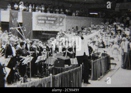 Fin années 1970 photographie vintage en noir et blanc d'un chef d'orchestre portant un tuxedo qui s'inclinent devant le public. Banque D'Images