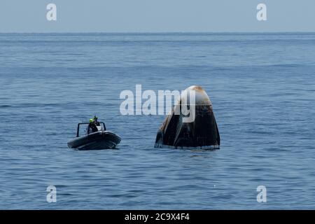 Des équipes de soutien arrivent à bord du vaisseau spatial SpaceX Crew Dragon Endeavour peu après son atterrissage avec les astronautes de la NASA Robert Behnken et Douglas Hurley dans le golfe du Mexique, au large de la côte de Pensacola, en Floride, le 2 août 2020. Le vol d'essai Demo-2 pour le programme des équipages commerciaux de la NASA a été le premier à livrer des astronautes à la Station spatiale internationale et à les ramener sur Terre en toute sécurité à bord d'un vaisseau spatial construit et exploité commercialement. Behnken et Hurley sont revenus après avoir passé 64 jours dans l'espace. NASA photo par Bill Ingalls/UPI Banque D'Images