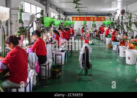 (200803) -- NANNING, 3 août 2020 (Xinhua) -- des gens sont occupés à travailler à un atelier de lutte contre la pauvreté dans le comté de Wuxuan, dans la région autonome de Guangxi Zhuang, dans le sud de la Chine, le 18 juin 2020. Guangxi, une région clé de la mission de lutte contre la pauvreté en Chine, a déployé des efforts constants pour gagner la dure bataille contre la pauvreté en assurant l'emploi de la population pauvre. Tenter de faire travailler les gens a joué un rôle essentiel dans la campagne à grande échelle de Guangxi pour lutter contre la pauvreté, car elle peut sortir toute la famille de la pauvreté. Elle a prouvé le moyen le plus efficace et le plus direct pour aider à combattre la pauvreté. Ajout Banque D'Images