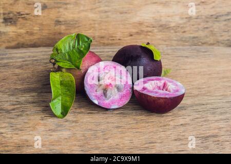 Fruits frais de Chrysophyllum cainito sur fond de bois Banque D'Images