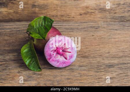 Fruits frais de Chrysophyllum cainito sur fond de bois Banque D'Images