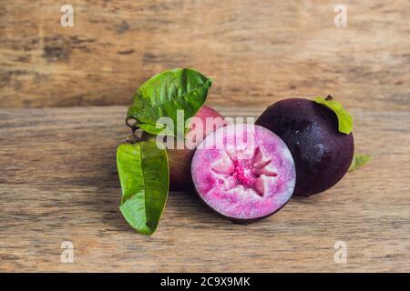 Fruits frais de Chrysophyllum cainito sur fond de bois Banque D'Images