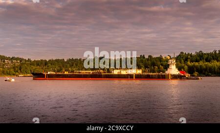 Un pétrolier amarré au coucher du soleil près de la raffinerie de Burnaby, niché dans un paysage immaculé le long des rives de Burrard Inlet et du port de Vancouver Banque D'Images