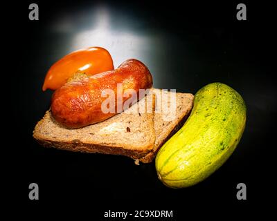Saucisses de viande fumée avec du pain et du concombre. Banque D'Images