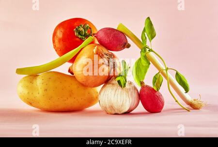 Une composition gastronomique avec des légumes colorés sur fond rose, pour une gastronomie amusante et une recette végétarienne. Équilibre flottant nourriture balanc Banque D'Images