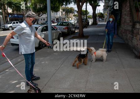 Une paire de randonneurs s'arrête pour une discussion sur le trottoir dans le quartier de Noe Valley à San Francisco, CA, USA. Banque D'Images