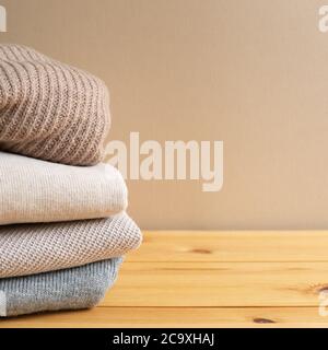Pile de vêtements chauds sur table en bois. Concept automne et hiver. Avec espace copie Banque D'Images