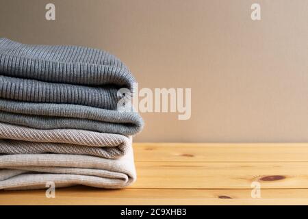 Pile de vêtements chauds sur table en bois. Concept automne et hiver. Avec espace copie Banque D'Images