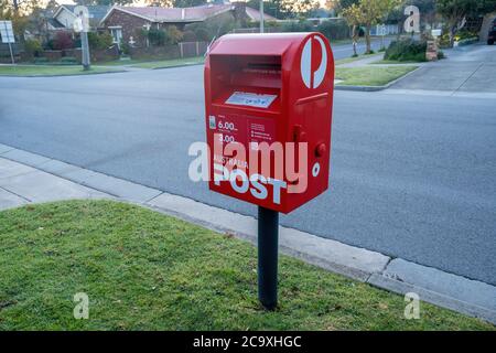 Melbourne, Australie - vers mai 2020 : boîte postale rouge sur la rue de banlieue Banque D'Images