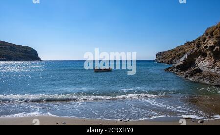 Petit bateau sur la mer, réflexions sur l'eau de mer calme, fond bleu ciel clair, plage de sable Spathi. Grèce. Île de Kea. Banque D'Images