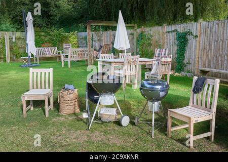 Barbecues et mobilier d'extérieur en bois d'iroko dans un jardin à l'arrière. Banque D'Images