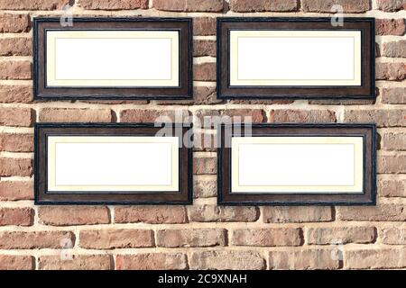 Quatre cadres en bois d'époque vides sur un vieux mur de briques. Cadre rétro vierge sur le mur de la salle. Modèle de maquette. Copier l'espace pour le texte Banque D'Images