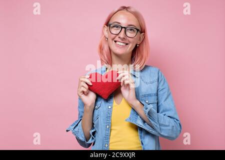 Femme caucasienne aux cheveux roses teints et au cœur rouge Banque D'Images