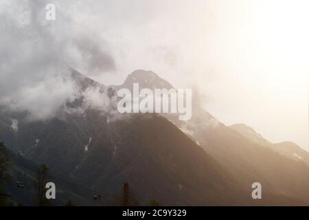 Les montagnes du matin s'inclinent dans des nuages bas avec enveloppé de brume dans un paysage pittoresque par temps pluvieux dans les montagnes Banque D'Images