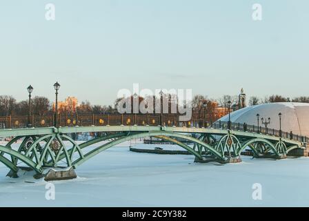 Pont en arcuate métallique vert ajouré au-dessus d'un réservoir gelé dans le parc Tsaritsino à Moscou en Russie. Paysage d'hiver Banque D'Images