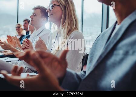 Les hommes d'affaires se sont mis à la main après une conférence réussie. Groupe d'hommes et de femmes applaudissant après une réunion productive. Banque D'Images