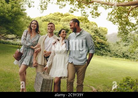 Groupe d'hommes et de femmes en cours de pique-nique. Deux couples dans le parc pour un pique-nique. Banque D'Images