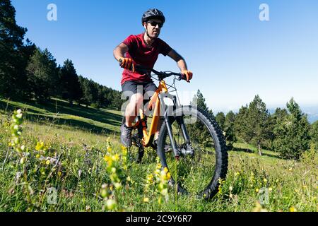 homme à vélo de montagne dans un pré avec des fleurs, concept de sport et un mode de vie sain dans la nature Banque D'Images