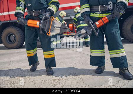 Hommes portant un uniforme de protection debout devant la machine Fire Modern Banque D'Images