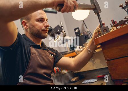 Artisan spécialisé travaillant avec un marteau Banque D'Images