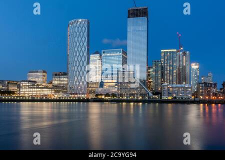 Vue sur la Tamise depuis l'ouest au coucher du soleil avec reflet dans l'eau. Isle of Dogs, Londres, Royaume-Uni. Architecte : divers, 2020. Banque D'Images