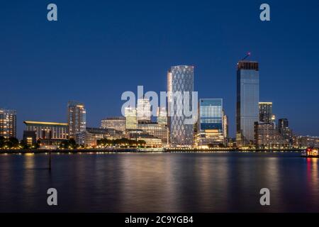 Vue sur la Tamise depuis l'ouest au coucher du soleil avec reflet dans l'eau. Isle of Dogs, Londres, Royaume-Uni. Architecte : divers, 2020. Banque D'Images