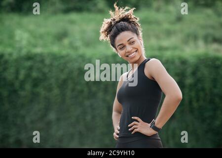 Modèle sportif ou blogueur de forme physique. Fille souriante dans les vêtements de sport avec tracker de forme physique Banque D'Images