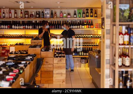 Les ponts de ce/ France - août 02 2020: Port d'un masque médical jetable dans un magasin de vigne. Protection et prévention des mesures en période épidémique. Banque D'Images