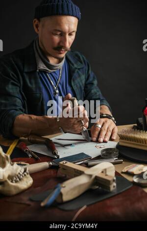 Conception Modélisation des souliers faits sur mesure. Lieu de travail de créateur de chaussures. Creative designer avec moustache et à la mode de travail pac avec nouvelle pièce sur bla Banque D'Images