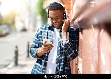 Portrait d'un gars écoutant de la musique penchée sur le mur Banque D'Images