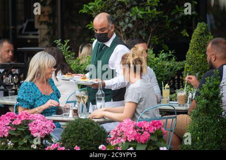 Les clients peuvent manger à l'extérieur de l'Ivy Market Grill, à Londres, l'un des restaurants participants où les clients pourront déguster des repas à moitié prix, à partir de lundi, alors que le gouvernement lance son programme d'août visant à stimuler le commerce des restaurants et des pubs après le verrouillage. Banque D'Images