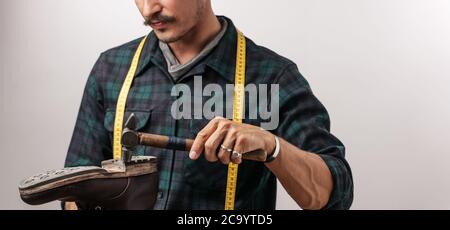 Portrait de méconnaissable schuster avec une bande de mesure et d'un marteau, effectue l'artisan cordonnier dans l'atelier de plaisance Banque D'Images