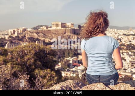 Jeune femme sur fond de paysage urbain d'Athènes, Grèce, Europe. Adulte jolie fille touriste se détend sur la colline surplombant l'Acropole d'Athènes i Banque D'Images
