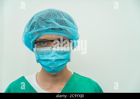 Gros plan portrait d'un chirurgien mâle mature dans la salle d'opération, travailleur médical masculin avec masque médical regardant sérieusement la caméra, espace pour le texte, se Banque D'Images
